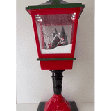 Luz de Navidad: farol rojo y verde con escena iluminada y nieve en movimiento.